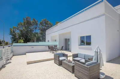 a patio with a couch and chairs on a house at Panayia Sea View Apts in Protaras