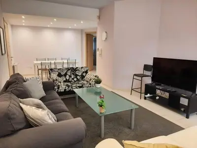 a living room with a couch and a table and a television at Apartment Sleeps 6 with Ensuite in Nicosia