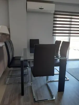 a table and chairs in a room with a window at Universe House in Mor Menekshe
