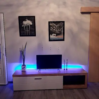 a living room with a television on a dresser with lights at Universe House in Mor Menekshe