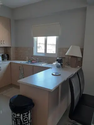 a kitchen with a counter and a table and a lamp at Universe House in Mor Menekshe