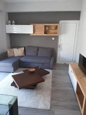 a living room with a blue couch and a table at Universe House in Mor Menekshe