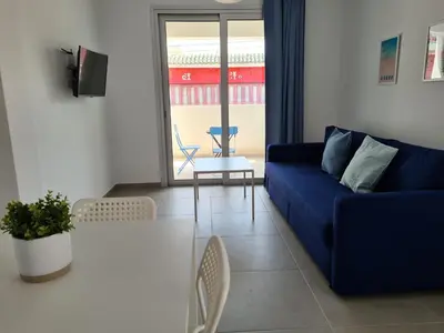 a living room with a blue couch and a table at Tefkrou Anthia 9 apts in Ayia Napa