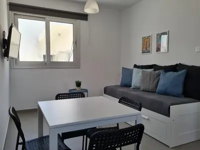 a living room with a couch and a table and chairs at Tefkrou Anthia 9 apts in Ayia Napa