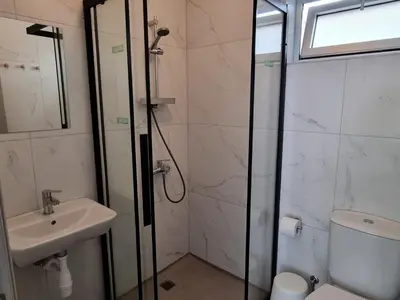 a bathroom with a shower and a sink and a toilet at Tefkrou Anthia 9 apts in Ayia Napa