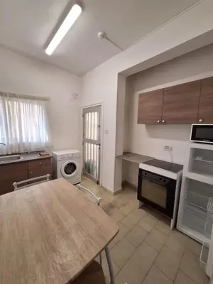a kitchen with a wooden table and a kitchen with a stove and a sink at TERPSICHORE Holiday Apts in Limassol