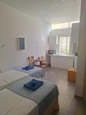 a room with two beds with blue towels on them at TERPSICHORE Holiday Apts in Limassol