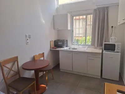 a small kitchen with a table and a microwave at TERPSICHORE Holiday Apts in Limassol