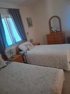 a bedroom with two beds and two windows at Melanta Villa in Pissouri