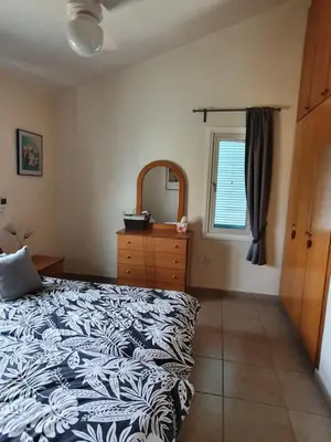 a bedroom with a bed and a dresser and a mirror at Melanta Villa in Pissouri
