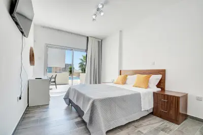 a bedroom with a large bed and a balcony at MyHome DeLux, Ayia Napa 3 Bedroom with Pool in Ayia Napa