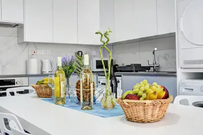 a kitchen counter with baskets of fruit and wine bottles at MyHome DeLux, Ayia Napa 3 Bedroom with Pool in Ayia Napa