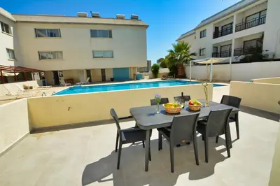 a table and chairs on a patio next to a pool at MyHome DeLux, Ayia Napa 3 Bedroom with Pool in Ayia Napa