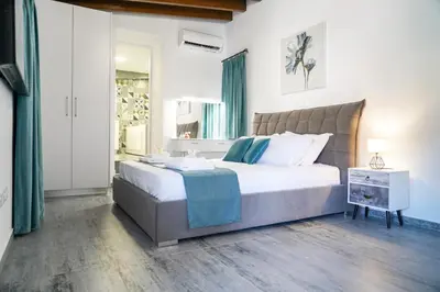 a bedroom with a large bed and a window at Kamaroporta Luxury Apartments in Ayios Theodhoros