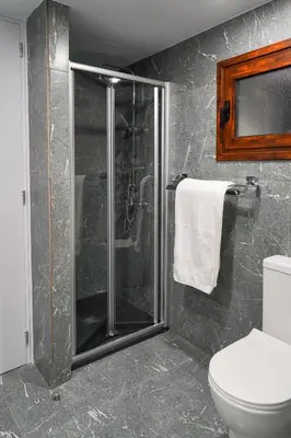 a bathroom with a shower and a toilet at Kamaroporta Luxury Apartments in Ayios Theodhoros
