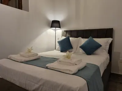 a bedroom with a bed with towels on it at Kamaroporta Luxury Apartments in Ayios Theodhoros
