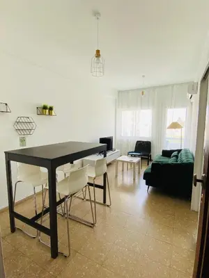 a living room with a black table and white chairs at Simple One bedroom flat in Engomi in Engomi