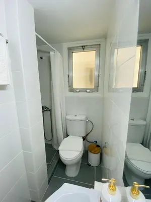 a white bathroom with a toilet and a sink at Simple One bedroom flat in Engomi in Engomi