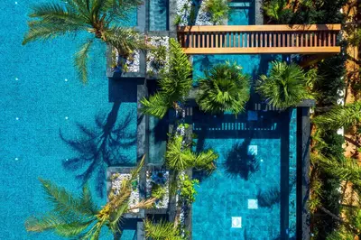 an overhead view of a swimming pool with palm trees at Amanti, MadeForTwo Hotels - Ayia Napa in Ayia Napa