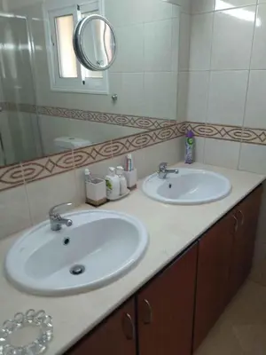 a bathroom with two sinks and a mirror at VillaHoliday in Voroklini