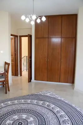 a bedroom with a large bed and wooden cabinets at VillaHoliday in Voroklini