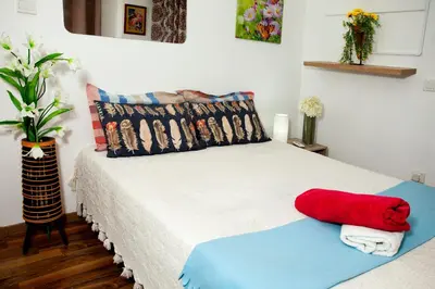 a bedroom with a bed with a red pillow on it at Nefeli Sea Side, Boutique Apartment in Limassol