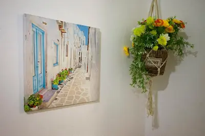 a painting hanging on a wall with a basket of flowers at Nefeli Sea Side, Boutique Apartment in Limassol