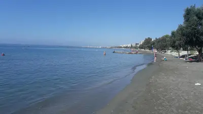 a beach with people swimming in the water at Nefeli Sea Side, Boutique Apartment in Limassol