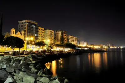 a city at night with a river and buildings at Nefeli Sea Side, Boutique Apartment in Limassol