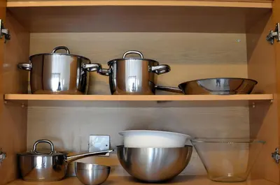 a kitchen with copper pots and pans on a shelf at Mirabella Mackenzie 1 Bedroom Flat Near the Sea in Larnaka
