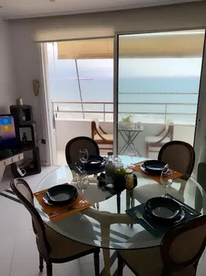 a dining room table with chairs and a view of the ocean at Larnaca Room, 50m to the Finikoudes beach in Larnaka