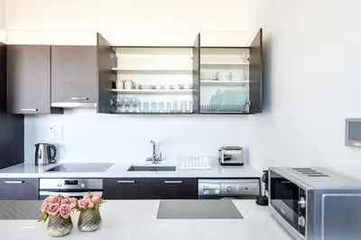 a kitchen with stainless steel appliances and a counter with flowers at Solaar Apartments st Lazarous in Larnaka