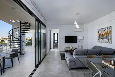 a living room with a couch and a tv at Solaar Apartments st Lazarous in Larnaka