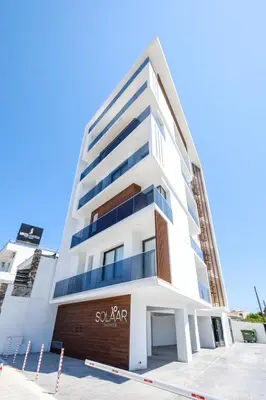a white building with a sign on it at Solaar Apartments st Lazarous in Larnaka