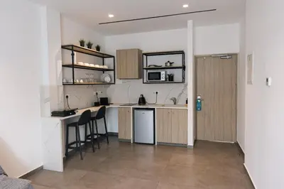 a kitchen with a counter and chairs in a room at Caramela Luxury Apts in Ayia Napa