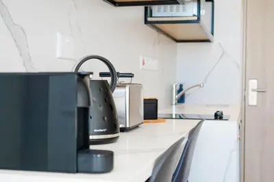 a kitchen counter with a tea kettle and a sink at Caramela Luxury Apts in Ayia Napa