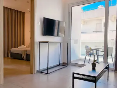 a living room with a flat screen tv on a wall at Caramela Luxury Apts in Ayia Napa