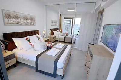 a bedroom with a bed and a living room at Golden Tree Apartment in Paralimni