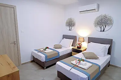 two beds in a hotel room with flowers on them at Golden Tree Apartment in Paralimni