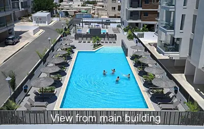 an overhead view of a swimming pool with umbrellas at Golden Tree Apartment in Paralimni
