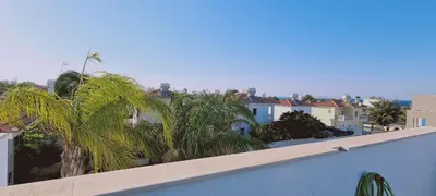 a view of palm trees and buildings from a balcony at STAY Trinity Beach Apts in Paralimni