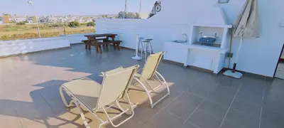 a patio with two chairs and a table on a roof at STAY Trinity Beach Apts in Paralimni