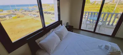 a bedroom with a bed and a view of the ocean at STAY Trinity Beach Apts in Paralimni