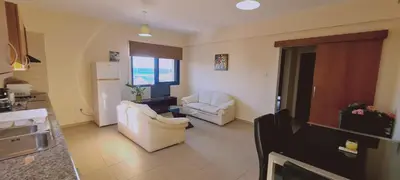 a kitchen and living room with two chairs and a refrigerator at STAY Trinity Beach Apts in Paralimni