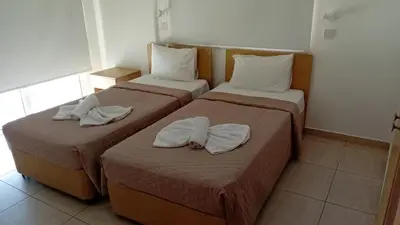 two beds in a hotel room with towels on them at Napa Charles Apts in Ayia Napa
