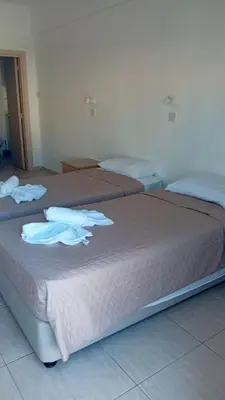 three beds in a room with towels on them at Napa Charles Apts in Ayia Napa