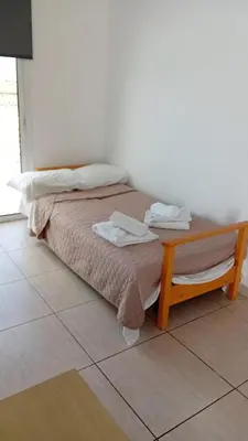 a bedroom with a bed and a table with a laptop on it at Napa Charles Apts in Ayia Napa