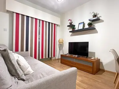 a living room with a couch and a flat screen tv at Albert's Apartment Mackenzie 001 in Larnaka