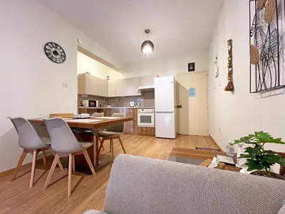 a kitchen and dining room with a table and chairs at Albert's Apartment Mackenzie 001 in Larnaka
