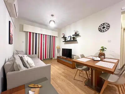 a living room with a couch and a wooden table at Albert's Apartment Mackenzie 001 in Larnaka